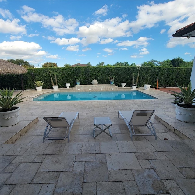 view of swimming pool with a patio area, fence, and a fenced in pool