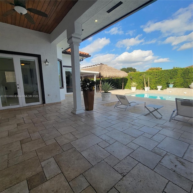 view of patio with french doors, a ceiling fan, and a fenced in pool