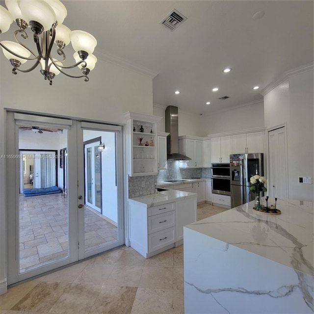 kitchen with visible vents, french doors, wall chimney range hood, open shelves, and stainless steel fridge