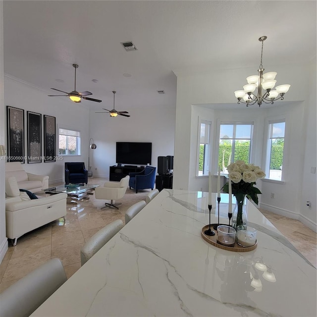 living area with a healthy amount of sunlight, visible vents, crown molding, and a notable chandelier