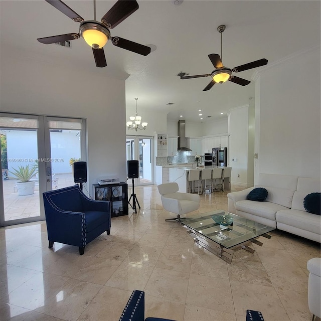 living area with ceiling fan with notable chandelier, crown molding, and french doors