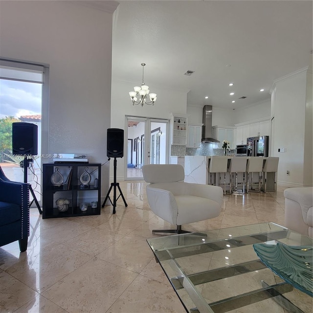 living area with ornamental molding, french doors, a healthy amount of sunlight, and an inviting chandelier