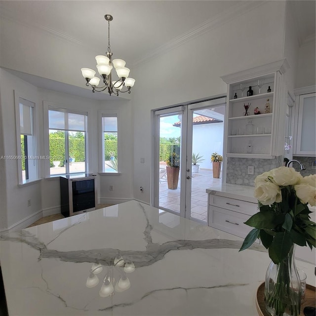 kitchen featuring white cabinetry, french doors, ornamental molding, light stone countertops, and open shelves