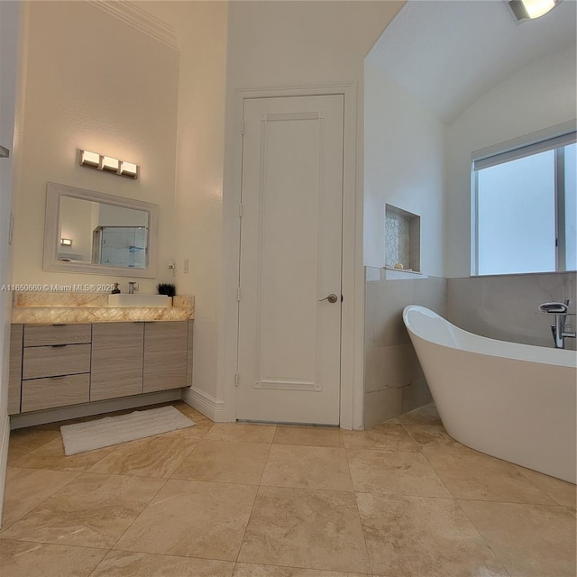 bathroom with lofted ceiling, a soaking tub, and vanity