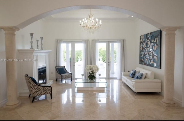 living area with marble finish floor, french doors, a tray ceiling, decorative columns, and crown molding