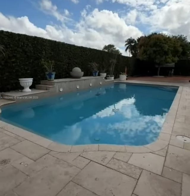 view of swimming pool featuring a patio, fence, and a fenced in pool