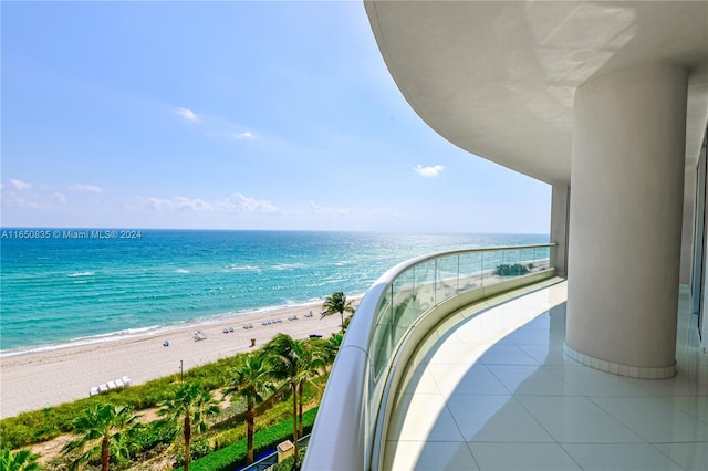 balcony featuring a water view and a view of the beach