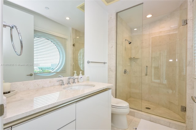 bathroom featuring a shower with door, vanity, toilet, and tile patterned flooring