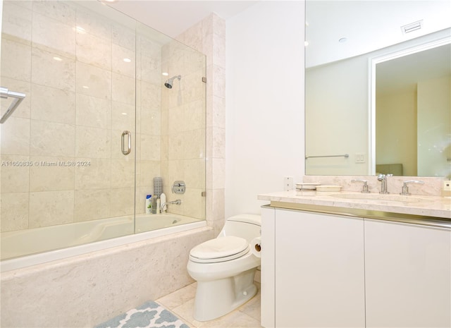 full bathroom with tile patterned floors, toilet, combined bath / shower with glass door, and vanity