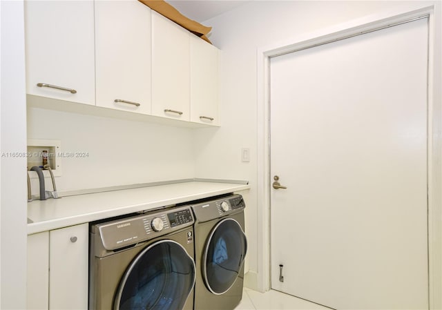 clothes washing area featuring cabinets, washer and clothes dryer, and light tile patterned floors