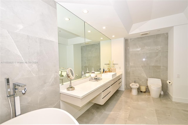 bathroom with a bidet, tile walls, toilet, and vanity