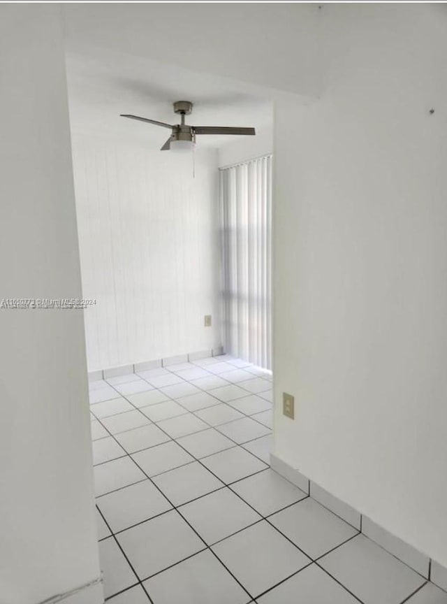 tiled empty room featuring ceiling fan