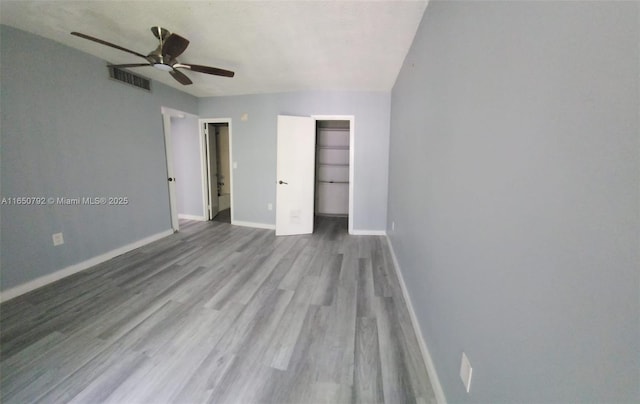 17620 Atlantic Blvd Unit 315, Sunny Isles Beach, FL 33160 - unfurnished bedroom featuring wood finished floors, a spacious closet, a closet, and a ceiling fan