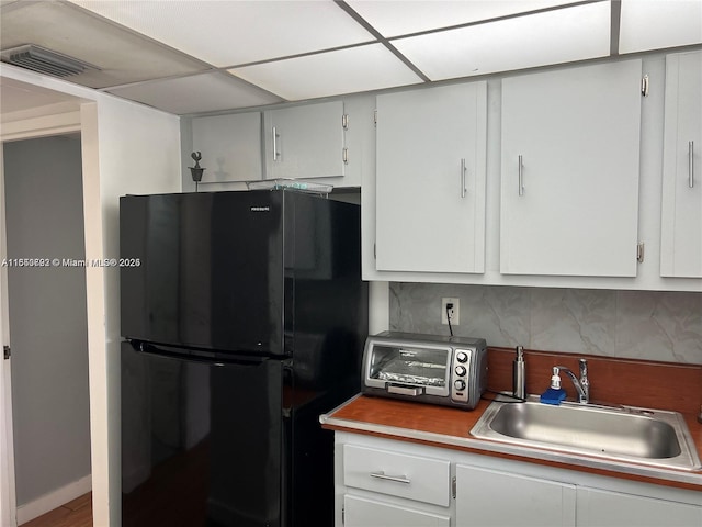 17620 Atlantic Blvd Unit 315, Sunny Isles Beach, FL 33160 - kitchen featuring freestanding refrigerator, tasteful backsplash, and white cabinetry