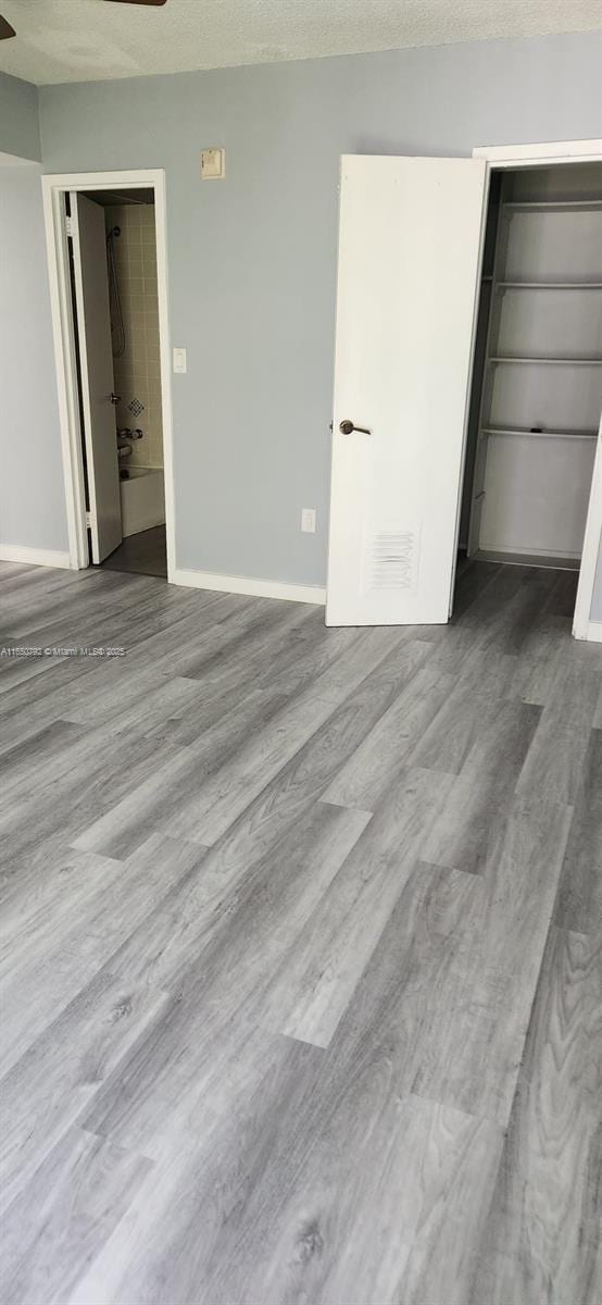 17620 Atlantic Blvd Unit 315, Sunny Isles Beach, FL 33160 - unfurnished bedroom with wood finished floors, a textured ceiling, and a ceiling fan