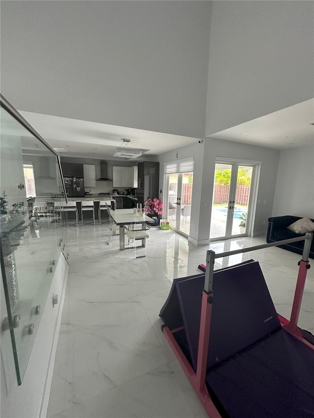 exercise area with a towering ceiling and french doors