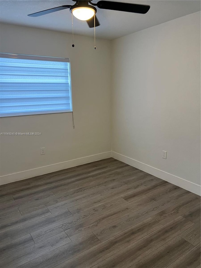 spare room featuring ceiling fan and dark wood-type flooring