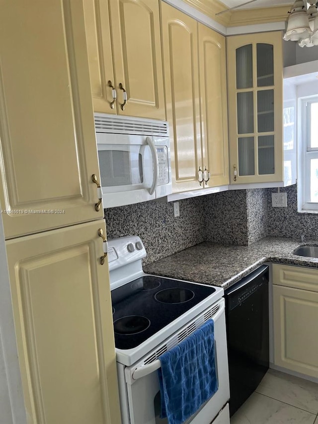 kitchen featuring cream cabinets, sink, white appliances, and decorative backsplash