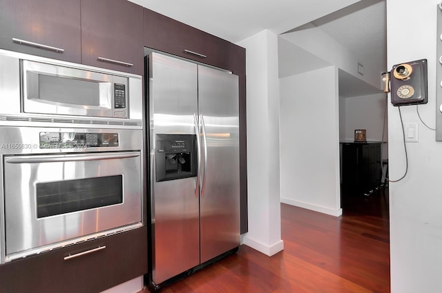 kitchen with dark wood-type flooring, dark brown cabinetry, and stainless steel appliances