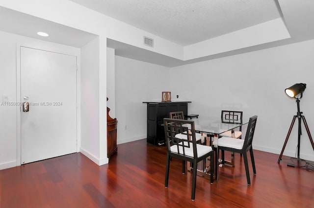 dining space with dark hardwood / wood-style flooring and a textured ceiling