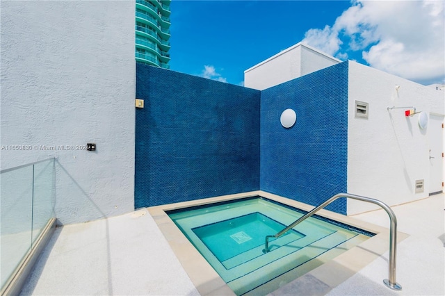 view of pool with an in ground hot tub