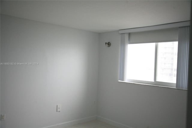 tiled spare room featuring a wealth of natural light