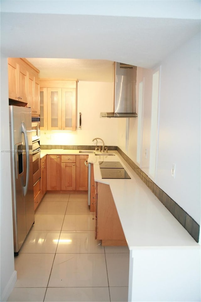 kitchen with kitchen peninsula, sink, appliances with stainless steel finishes, light tile patterned flooring, and wall chimney range hood