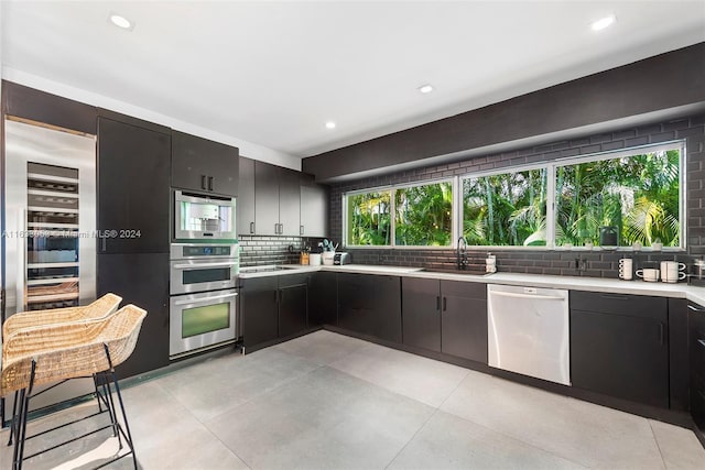 kitchen featuring stainless steel appliances, sink, and backsplash