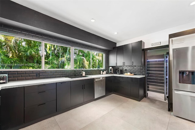 kitchen with stainless steel appliances, sink, and tasteful backsplash