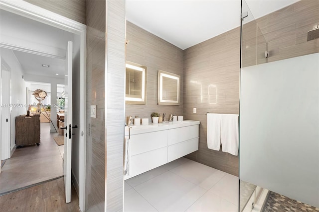 bathroom featuring a shower, tile walls, tile patterned flooring, and vanity