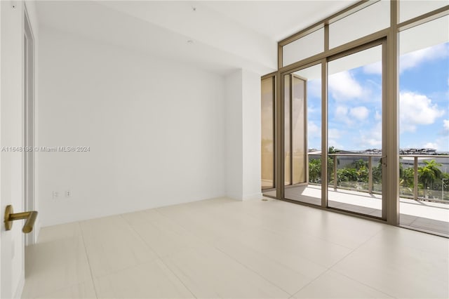 tiled spare room with a wall of windows