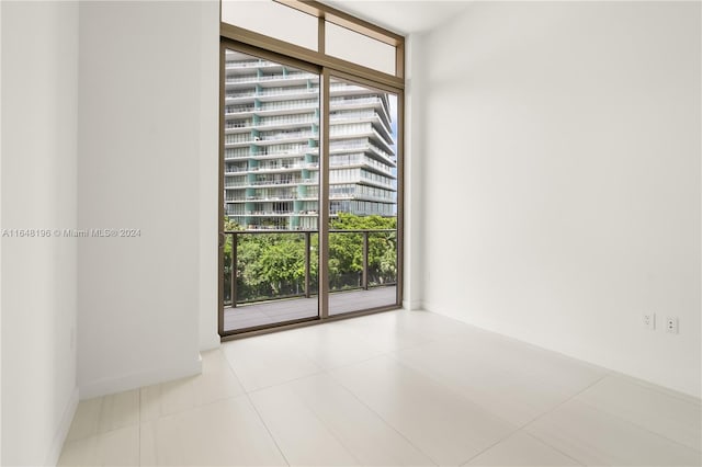 tiled spare room with floor to ceiling windows