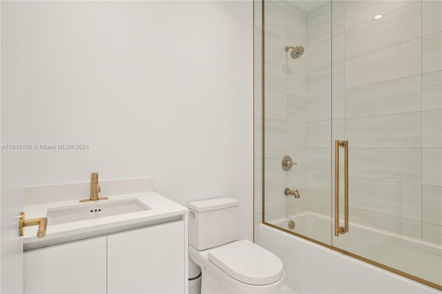 full bathroom featuring shower / bath combination with glass door, vanity, and toilet