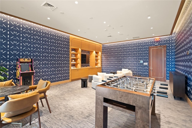 recreation room featuring light colored carpet and crown molding