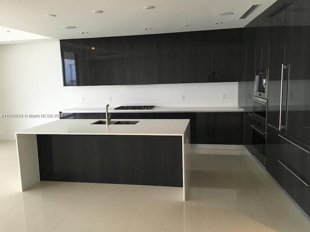 kitchen with an island with sink, stainless steel appliances, and sink