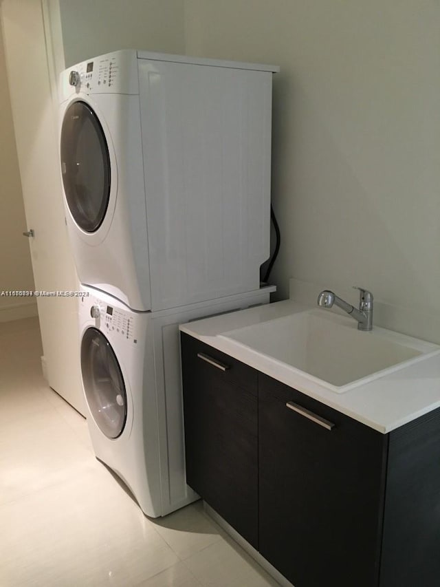 washroom featuring cabinets, sink, light tile patterned floors, and stacked washer and dryer