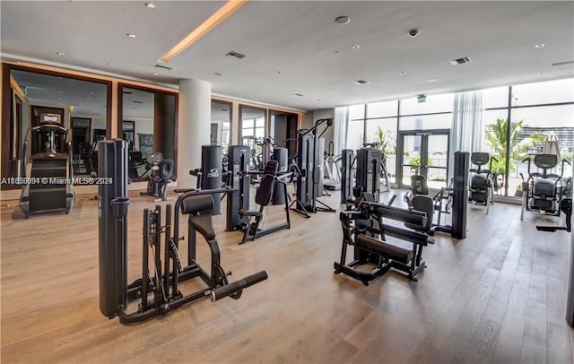 gym with floor to ceiling windows and light hardwood / wood-style flooring