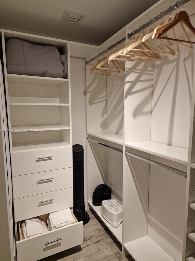 walk in closet with light hardwood / wood-style flooring