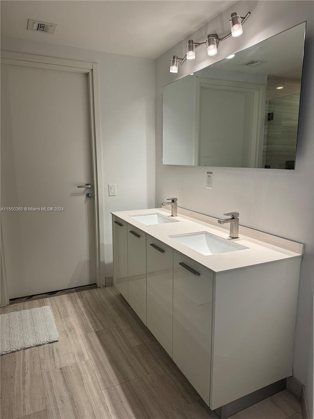 bathroom featuring hardwood / wood-style floors, vanity, and a shower with shower door