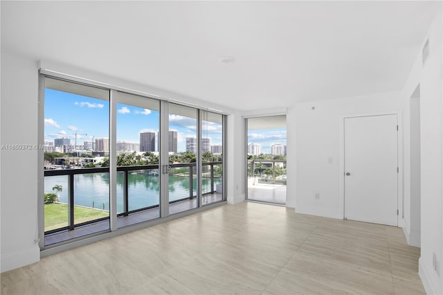 empty room featuring expansive windows, plenty of natural light, and a view of city