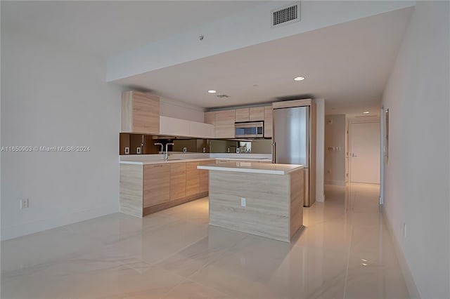 kitchen with light tile patterned floors, light brown cabinetry, and a center island