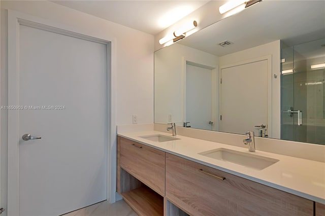 bathroom featuring a shower with shower door and vanity