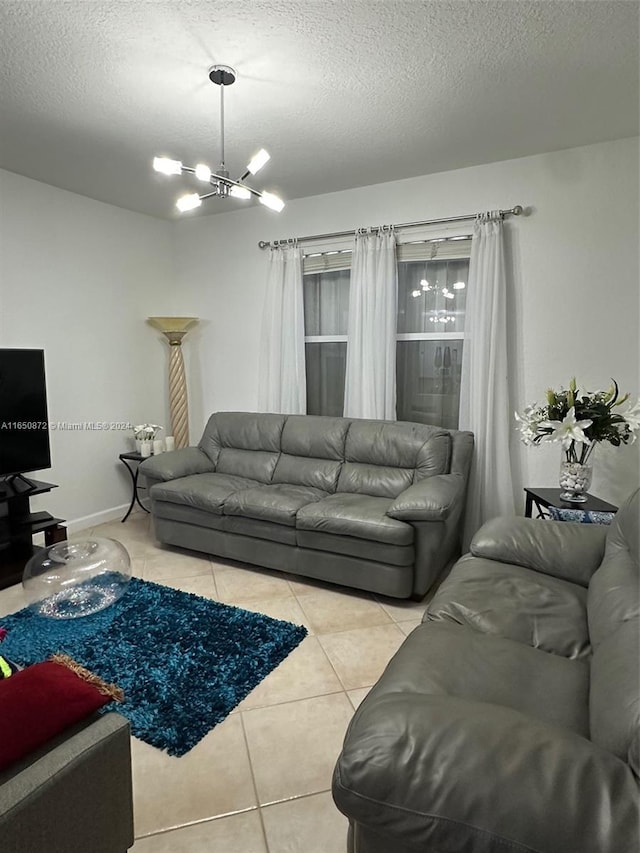 living room with light tile patterned floors, a textured ceiling, and an inviting chandelier