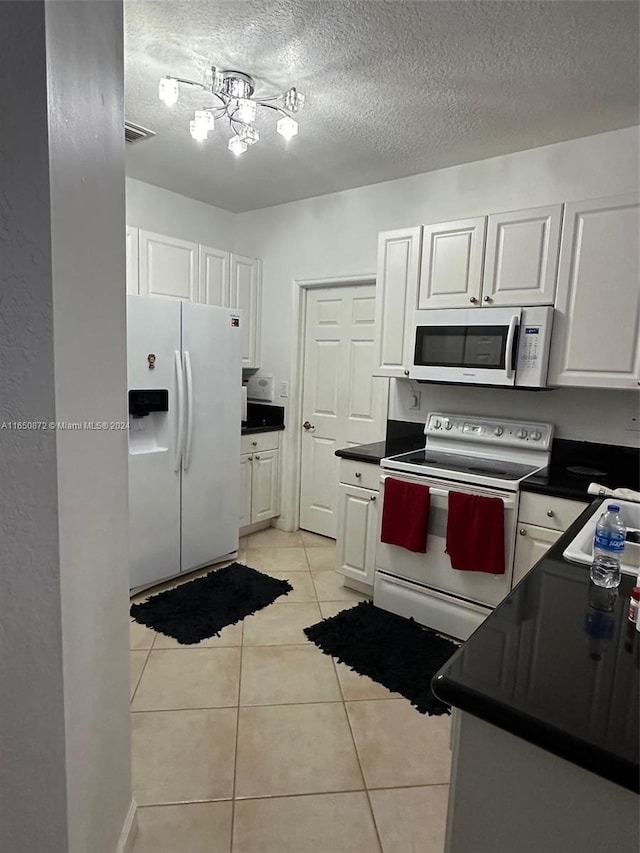 kitchen featuring white cabinetry, white appliances, light tile patterned floors, and a textured ceiling