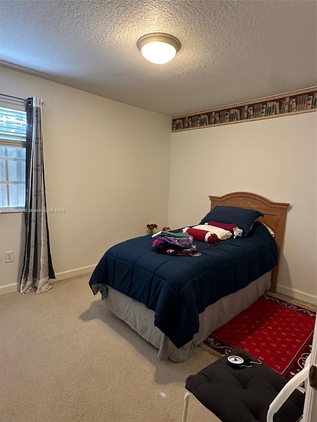 bedroom with light carpet and a textured ceiling