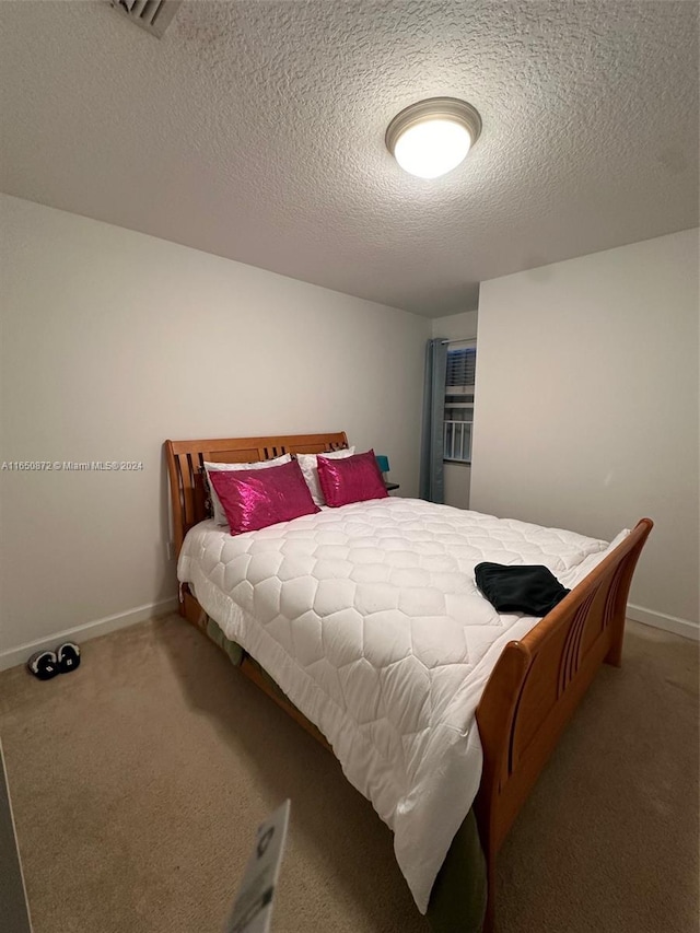 bedroom with a textured ceiling and carpet floors