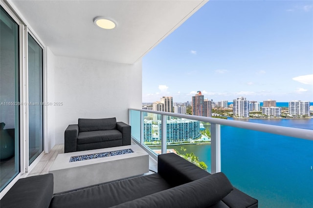 balcony featuring a water view and a fire pit