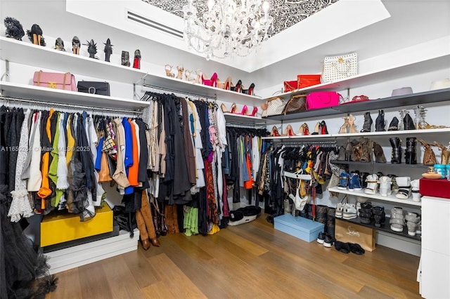 walk in closet featuring a chandelier and hardwood / wood-style floors