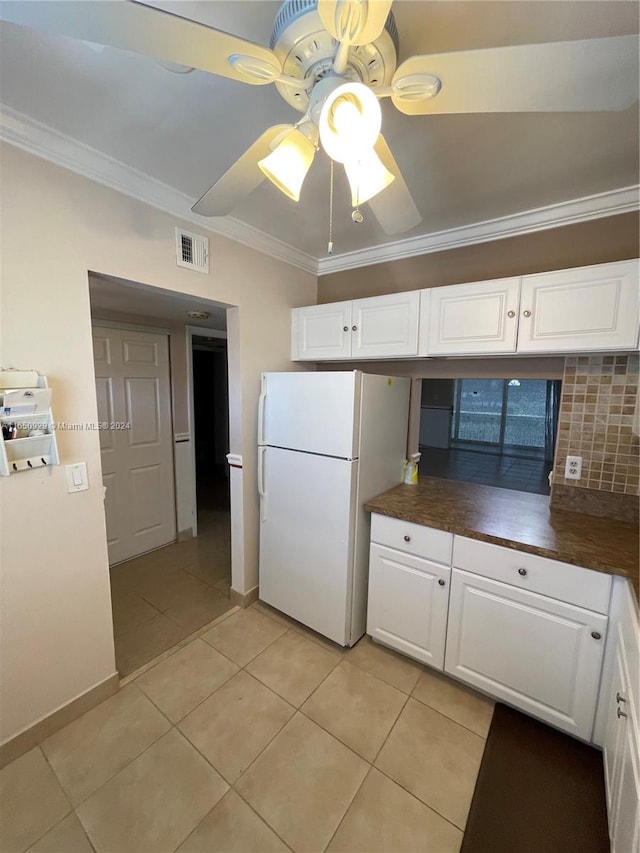 kitchen with tasteful backsplash, crown molding, white cabinetry, ceiling fan, and white refrigerator