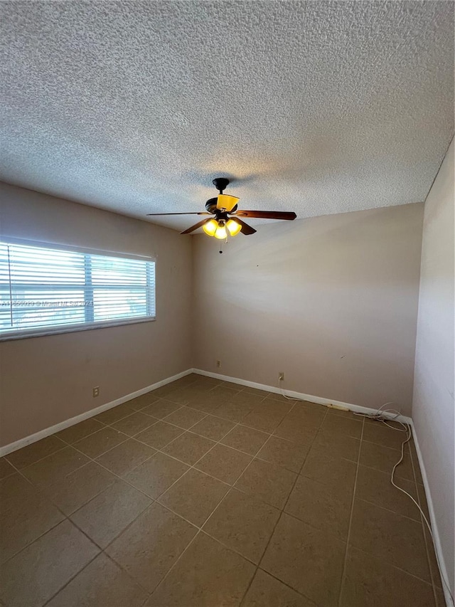 unfurnished room with a textured ceiling, ceiling fan, and tile patterned flooring